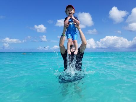 Man holding child over the ocean