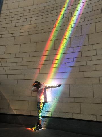 Rainbow from a prism shining down on a person from above